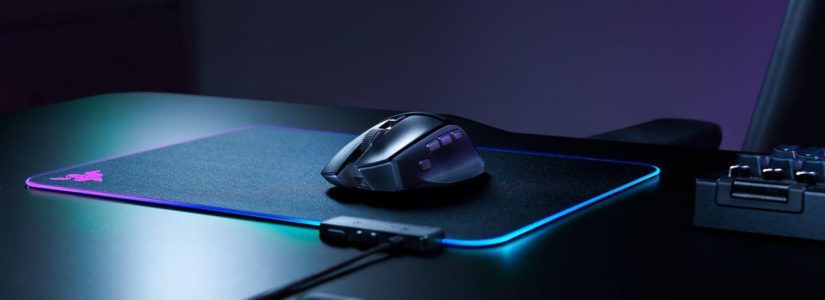 Basilisk V4 HyperSpeed 放在發光邊滑鼠墊上，前方有接收器