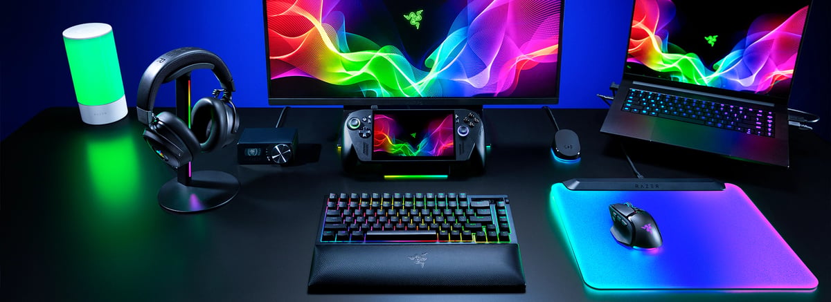桌上的 Basilisk V4 Pro、筆電、掌機與耳機